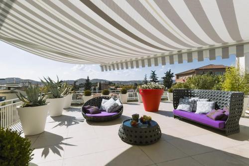 exteriors shots of a modern terrace with awnings and wicker sofa